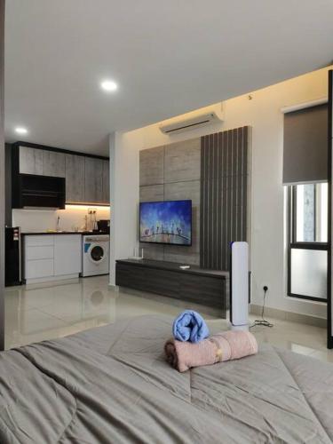 a bedroom with a large bed and a kitchen at Urban360 Pool view stylist with android Tv in Batu Caves