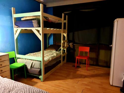 1 dormitorio con 2 literas y silla roja en St Kilda East backpackers' hostel, en Melbourne