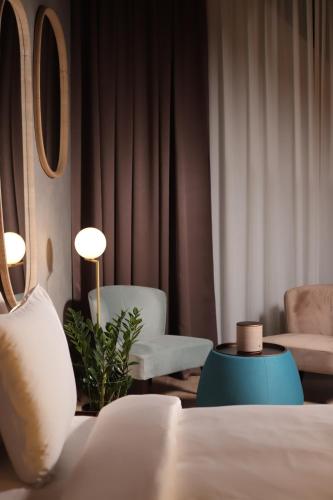 a hotel room with a bed and two chairs at The Veil Hotel in Astana