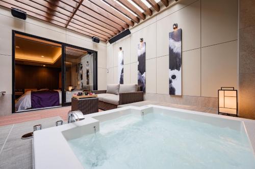 a large bath tub in a room with a bedroom at ホテルゼン離宮平野 in Osaka