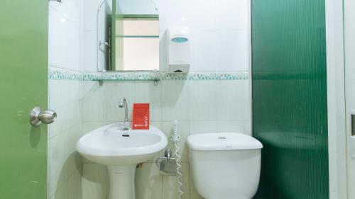 ein Badezimmer mit einem Waschbecken, einem WC und einem Spiegel in der Unterkunft RedDoorz @ Orsu Hotel Angeles Pampanga in Angeles