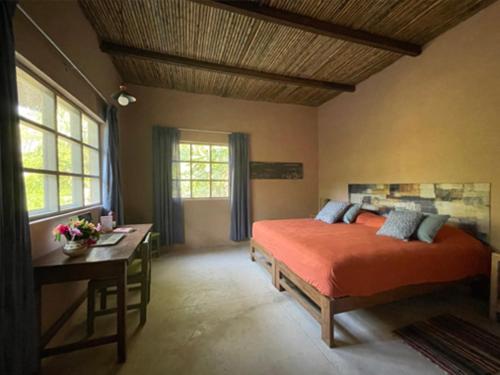 Schlafzimmer mit einem Bett, einem Schreibtisch und einem Fenster in der Unterkunft Casa Capirona 3 - Laguna Azul in Tarapoto