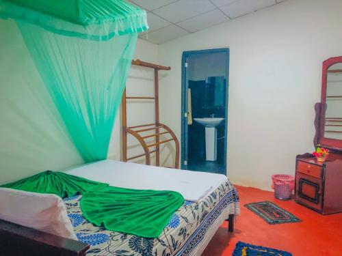 1 dormitorio con 1 cama con dosel verde en Green Grass Homestay, en Sigiriya