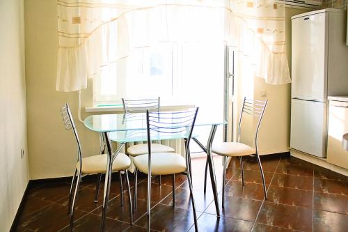 ロストフ・ナ・ドヌにあるAlliance Apartments at Teatralniyのキッチン(テーブル、椅子、冷蔵庫付)