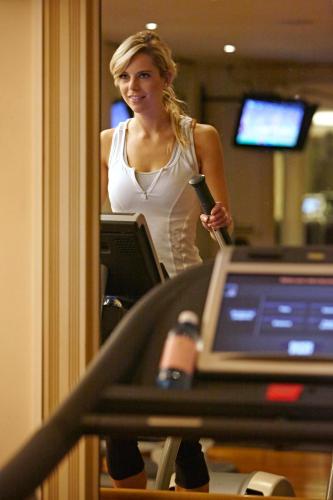 a woman standing in front of a mirror holding a brush at The Langham Sydney in Sydney