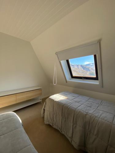 a bedroom with a bed and a window at Moderno Duplex en Tebas Las Leñas!!!!!! PRECIO CORRECTO EN USD BLUE, NO EN ARS in Las Lenas