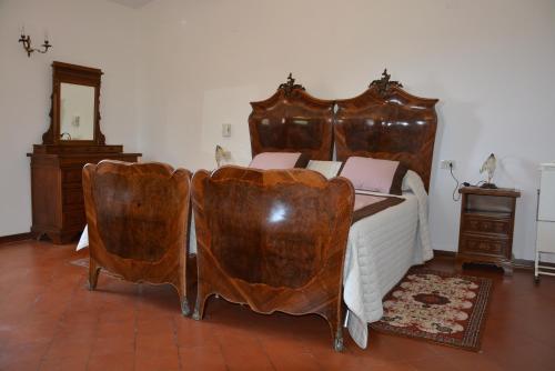 a bedroom with a large bed with leather chairs at Casale Fusco in Spoleto