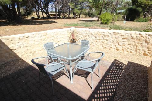a glass table and two chairs on a patio at BIG4 Cape Jervis Accommodation & Caravan Park in Cape Jervis