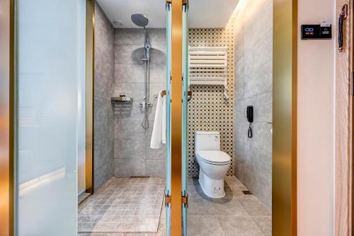 a bathroom with a toilet and a shower at Happy Dragon Universal Vacation Hotel - close to Universal Studio and Wanda Plaza,free shuttle to the Resort,Free Coffee,Laundry in Beijing