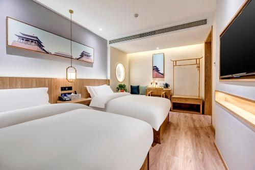 two beds in a hotel room with a flat screen tv at Happy Dragon Universal Vacation Hotel - close to Universal Studio and Wanda Plaza,free shuttle to the Resort,Free Coffee,Laundry in Beijing
