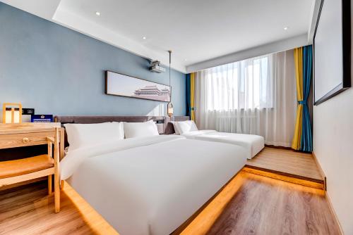 a bedroom with two beds and a desk at Happy Dragon Universal Vacation Hotel - close to Universal Studio and Wanda Plaza,free shuttle to the Resort,Free Coffee,Laundry in Beijing