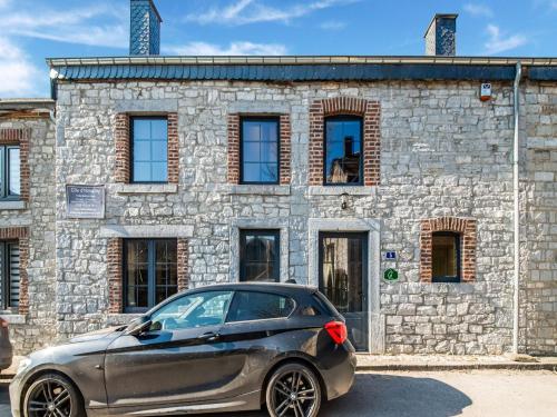 un coche aparcado frente a un edificio de piedra en Stone Cottage with Sauna Jacuzzi a 5 min drive from the cave of Lorette in Rochefort en Han-sur-Lesse