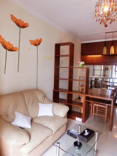 a living room with a couch and flowers on the wall at YuMi Gaopai in Guangzhou