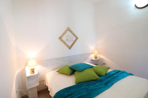 un letto bianco con cuscini verdi in una stanza di Casa Pizzutella Torre Santo Stefano in Otranto 3 places ad Alimini