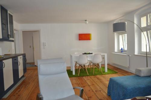 eine Küche und ein Wohnzimmer mit einem Tisch und Stühlen in der Unterkunft Apartment in der Altstadt in Ueckermünde