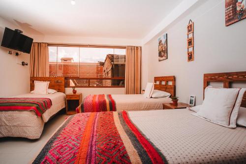 a hotel room with two beds and a window at Dreams House Cusco in Cusco