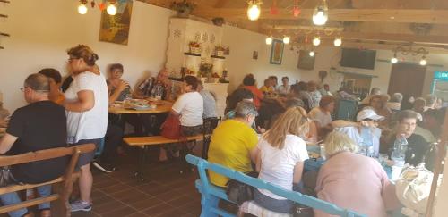 eine Gruppe von Personen, die in einem Restaurant an Tischen sitzen in der Unterkunft Pensiunea Ramona in Viscri