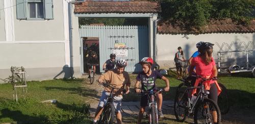 a group of people riding bikes in front of a building at Pensiunea Ramona in Viscri