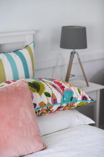 a bed with a pillow and a table with a lamp at The Sampson - Orange in Orange