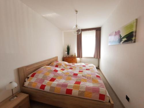um quarto com uma cama com uma colcha colorida em Deichblick em Westerdeichstrich