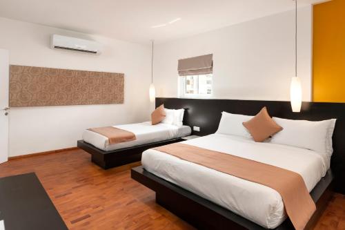 a hotel room with two beds in a room at TAO Riverside Residence in Phnom Penh