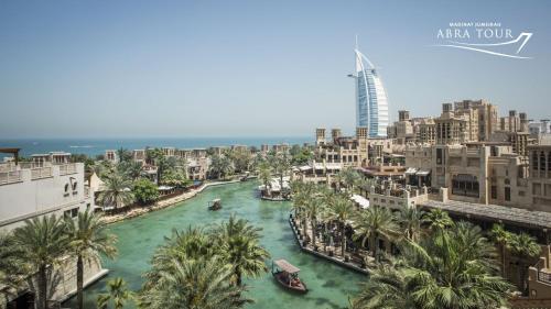 a river in the middle of a city with palm trees at Jumeirah Mina Al Salam Dubai in Dubai
