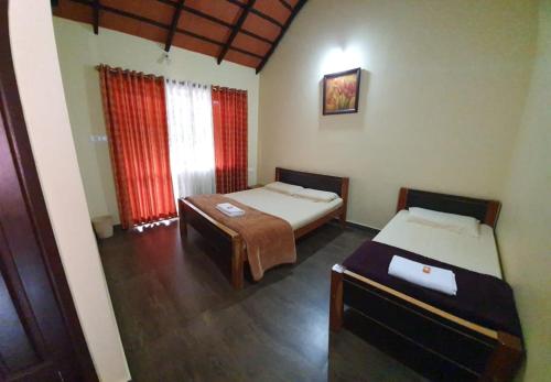 Zimmer mit 2 Betten und einem Tisch in der Unterkunft Foothills Homestay in Chikmagalur
