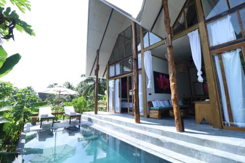 a house with a swimming pool next to a building at Satya Boutique Resort & Spa in Havelock Island
