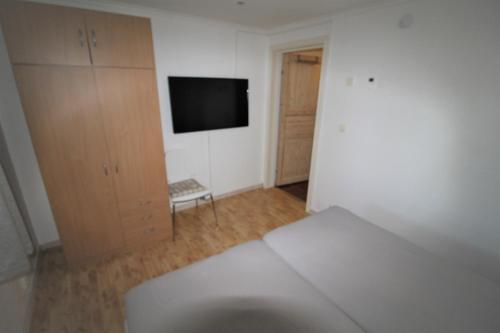 a bedroom with a bed and a tv in a room at Stokke Apartment in Stokke