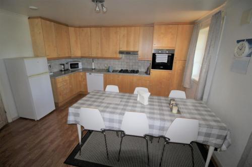 a kitchen with a table and chairs and a refrigerator at Stokke Apartment in Stokke