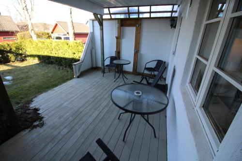 a patio with chairs and a table on a porch at Stokke Apartment in Stokke