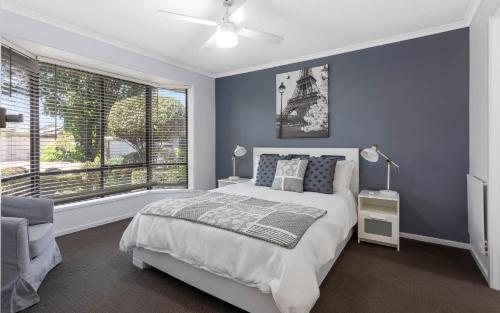 a bedroom with a bed and a large window at Islander Escape in Encounter Bay