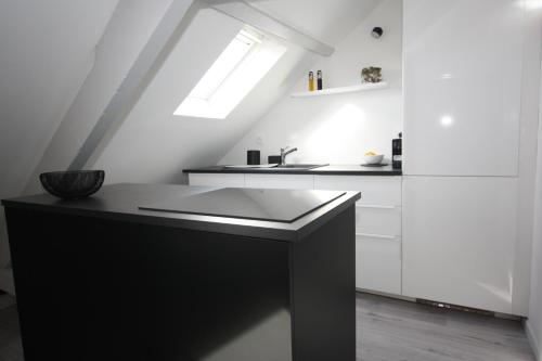 una cocina con encimera negra y fregadero en DU SEL A LA VIE, grand studio entre marais et océan, en Batz-sur-Mer