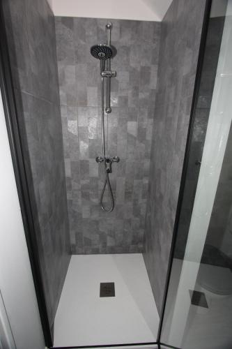 une cabine de douche avec une porte en verre et une douche. dans l'établissement DU SEL A LA VIE, grand studio entre marais et océan, à Batz-sur-Mer