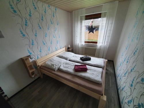 ein kleines Schlafzimmer mit einem Bett und einem Fenster in der Unterkunft Ferienhaus-Bogen-Glück in Osteel