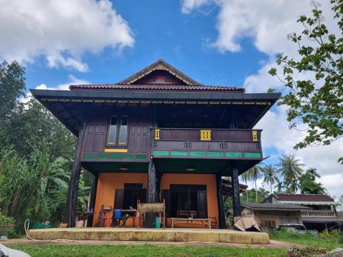 una casa con techo de paja encima en โฮมสเตย์บ้านนายสิงโตเขาคูหา, en Ban Khu Ha Nai (1)