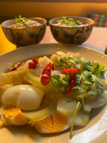 a plate of food with eggs and vegetables on a table at โฮมสเตย์บ้านนายสิงโตเขาคูหา in Ban Khu Ha Nai (1)