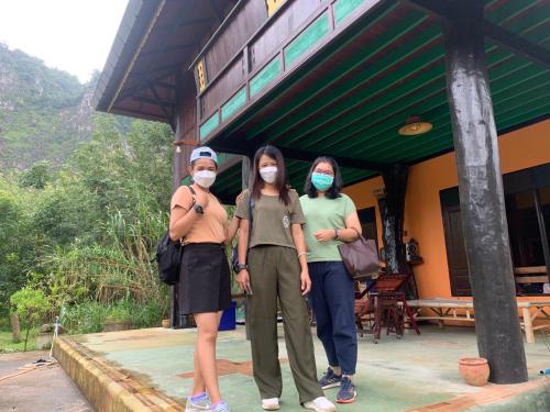 three people wearing face masks standing outside a building at โฮมสเตย์บ้านนายสิงโตเขาคูหา in Ban Khu Ha Nai (1)