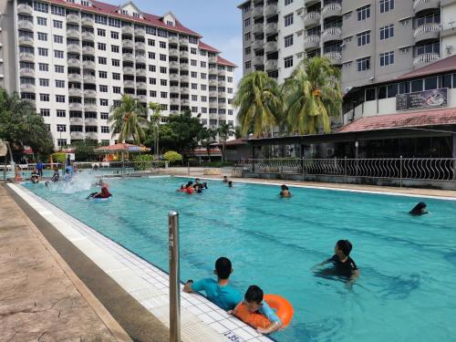 a group of people swimming in a swimming pool at Beach View Private Apartment in Port Dickson