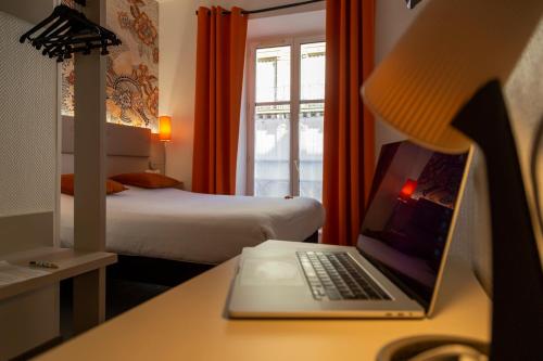 a hotel room with a laptop computer on a desk at Hotel Victoria in Strasbourg