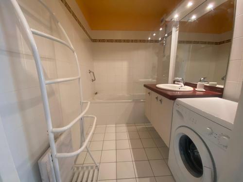 une salle de bain avec une machine à laver et un lavabo dans l'établissement L Horizon vue mer, à Wimereux