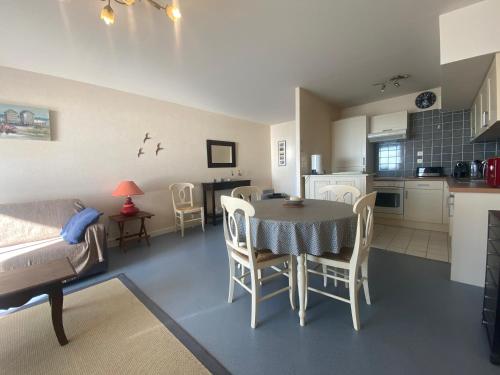 une cuisine et une salle à manger avec une table et des chaises dans l'établissement L Horizon vue mer, à Wimereux