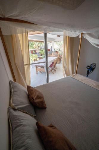 a bedroom with a bed with pillows and a patio at la villa sur la plage in Palmarin