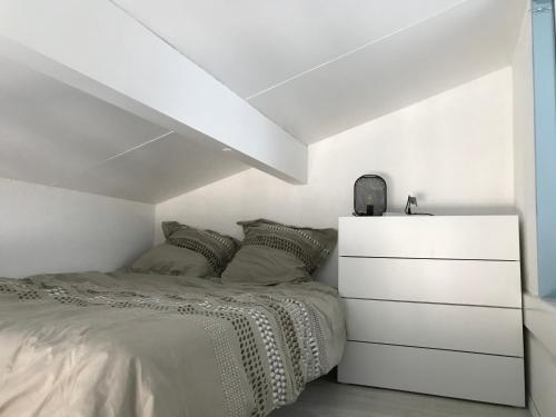 - une chambre blanche avec un lit et une commode dans l'établissement Appartement cosy en résidence privée avec vue mer, à Soulac-sur-Mer