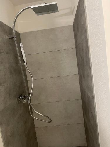 La salle de bains est pourvue d'une douche avec un pommeau de douche. dans l'établissement Appartement cosy en résidence privée avec vue mer, à Soulac-sur-Mer