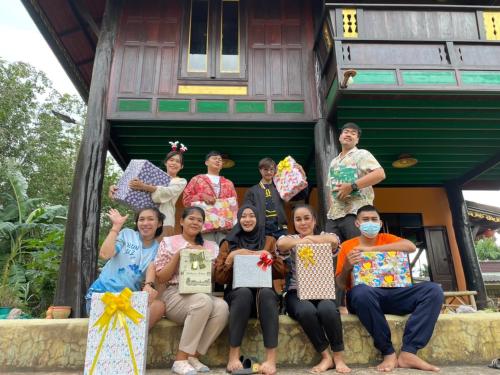a group of people posing for a picture in front of a house at โฮมสเตย์บ้านนายสิงโตเขาคูหา in Ban Khu Ha Nai (1)