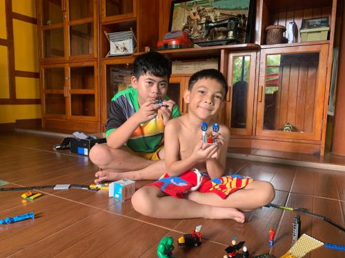 two young boys sitting on the floor with legos at โฮมสเตย์บ้านนายสิงโตเขาคูหา in Ban Khu Ha Nai (1)