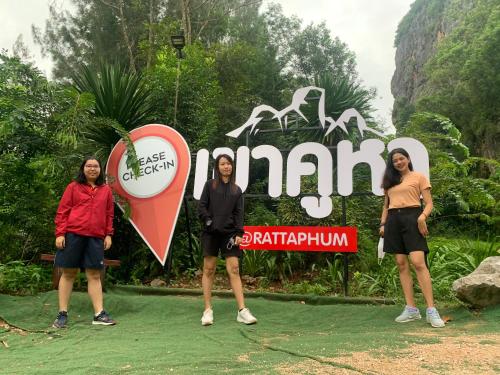 a group of women standing in front of a sign at โฮมสเตย์บ้านนายสิงโตเขาคูหา in Ban Khu Ha Nai (1)