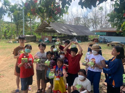 a group of children are holding up toy animals at โฮมสเตย์บ้านนายสิงโตเขาคูหา in Ban Khu Ha Nai (1)