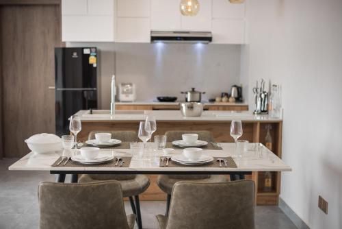 a kitchen with a table and chairs with glasses on it at AMATA Residence in Phnom Penh